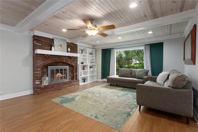 10234 Monrovia St, Lenexa, KS 66215 - living area with wood finished floors, wooden ceiling with exposed beams, baseboards, a ceiling fan, and a brick fireplace
