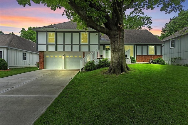 10234 Monrovia St, Lenexa, KS 66215 - view of front facade featuring driveway, a garage, brick siding, and a front yard