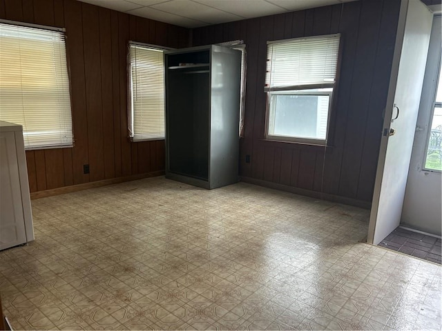 unfurnished bedroom featuring wood walls and baseboards