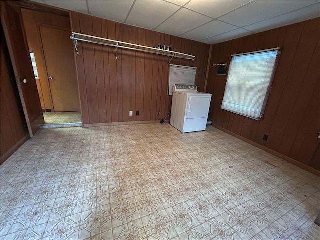 laundry area featuring washer / clothes dryer, wooden walls, light flooring, and baseboards