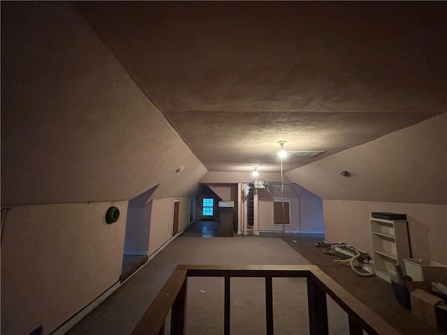 additional living space featuring lofted ceiling and carpet