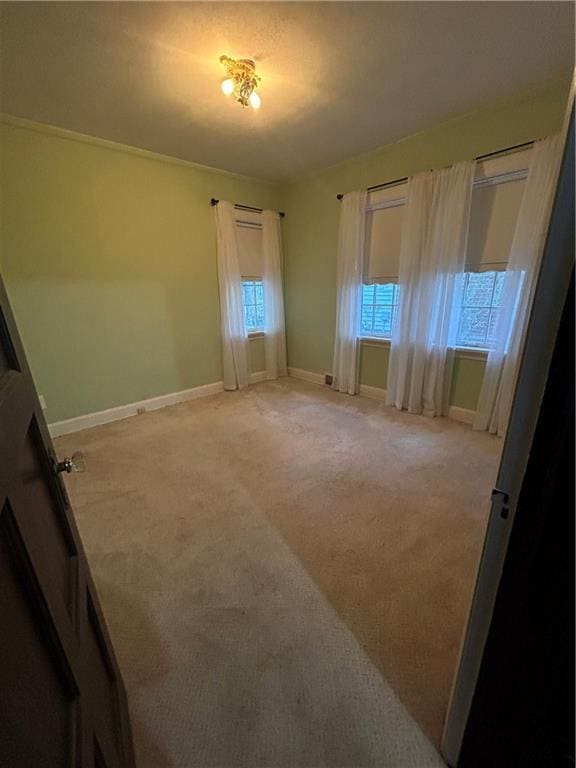 empty room with light colored carpet and baseboards