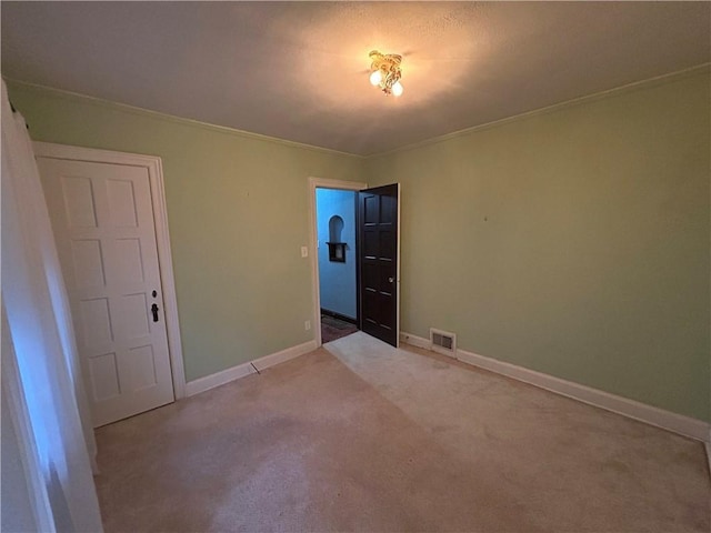 spare room with carpet flooring, baseboards, and ornamental molding