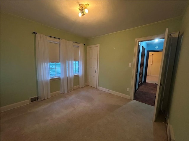 unfurnished bedroom featuring light colored carpet and baseboards