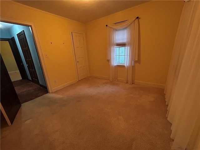 spare room featuring baseboards and carpet