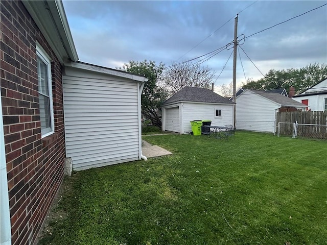 view of yard with a detached garage and an outbuilding