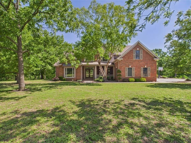 1051 205th St, Fort Scott, KS 66701 - view of front of home with french doors, a front yard, and brick siding