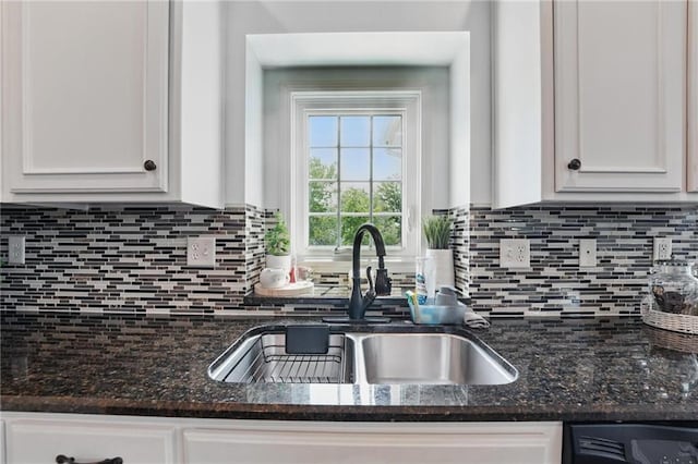 1605 NW Primrose Ln, Blue Springs, MO 64015 - kitchen with white cabinetry, backsplash, dark stone countertops, and black dishwasher