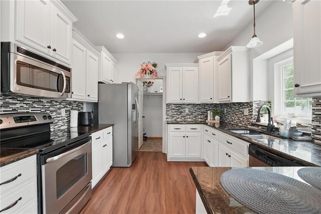 1605 NW Primrose Ln, Blue Springs, MO 64015 - kitchen with appliances with stainless steel finishes, white cabinets, light wood finished floors, decorative backsplash, and recessed lighting