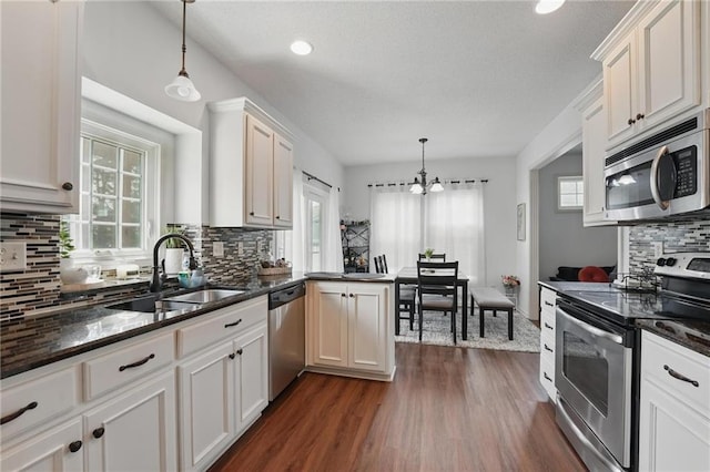 1605 NW Primrose Ln, Blue Springs, MO 64015 - kitchen with stainless steel appliances, healthy amount of natural light, decorative backsplash, a chandelier, and recessed lighting