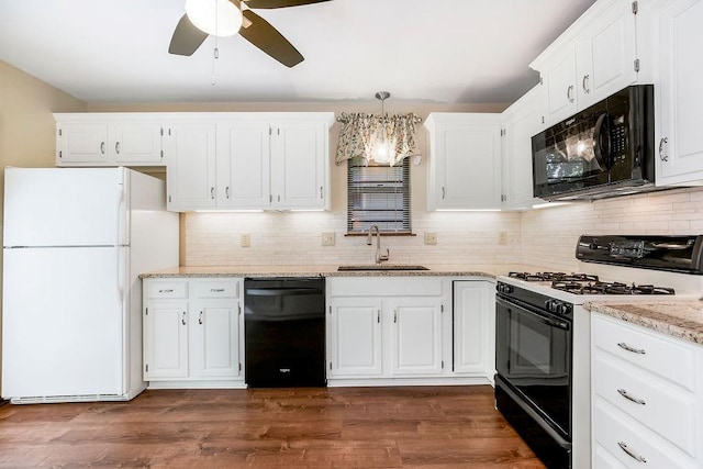 5004 S Kendall Dr, Independence, MO 64055 - kitchen with black appliances, white cabinetry, tasteful backsplash, ceiling fan, and light stone counters