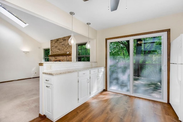 5004 S Kendall Dr, Independence, MO 64055 - kitchen featuring freestanding refrigerator, a peninsula, white cabinetry, ceiling fan, and pendant lighting