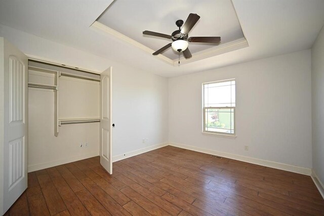 15790 NW 125th St, Platte City, MO 64079 - unfurnished bedroom featuring a raised ceiling, baseboards, dark wood-style floors, and a closet