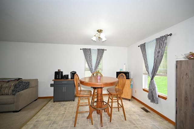 705 N Clark St, Edgerton, MO 64444 - dining area featuring a chandelier and baseboards