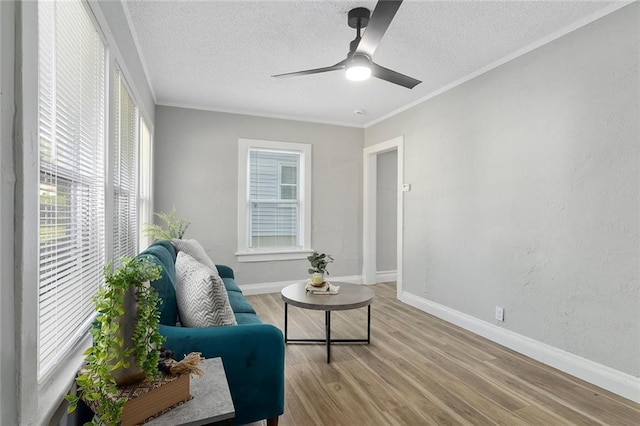sitting room featuring plenty of natural light, a textured ceiling, wood finished floors, ceiling fan, and baseboards