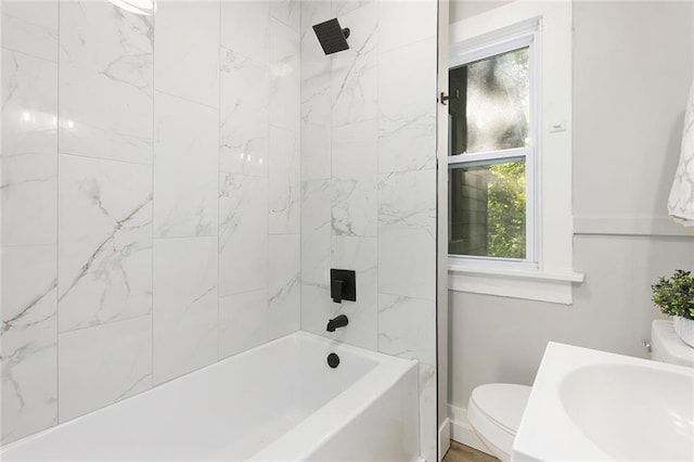 full bathroom with toilet, a sink, and baseboards