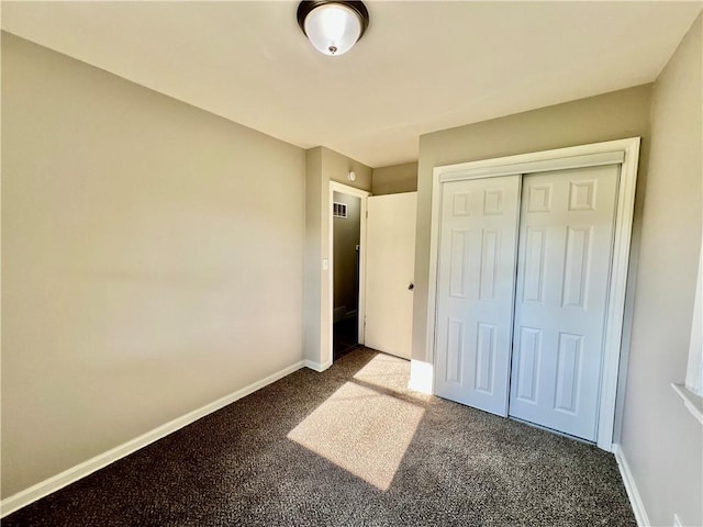 unfurnished bedroom featuring carpet, a closet, and baseboards