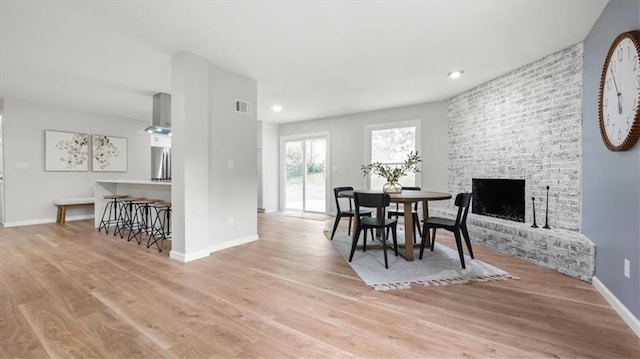 8741 Reeds Rd, Overland Park, KS 66207 - dining area with wood finished floors, baseboards, a large fireplace, and recessed lighting