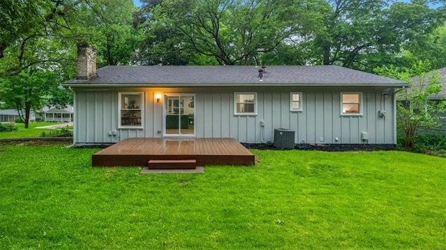 8741 Reeds Rd, Overland Park, KS 66207 - back of property with board and batten siding, a chimney, a wooden deck, a lawn, and central AC