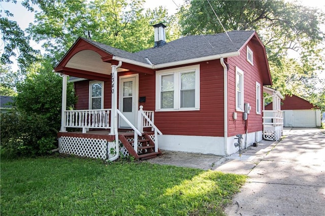 1340 S Osage St, Independence, MO 64055 - bungalow-style home with a porch, a front lawn, a chimney, a shingled roof, and an outbuilding