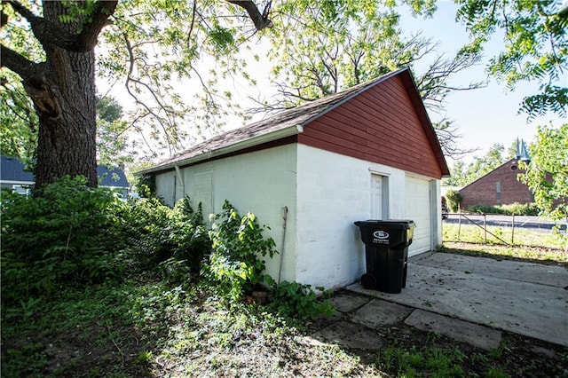 1340 S Osage St, Independence, MO 64055 - view of home's exterior featuring an outbuilding, a garage, concrete block siding, and fence