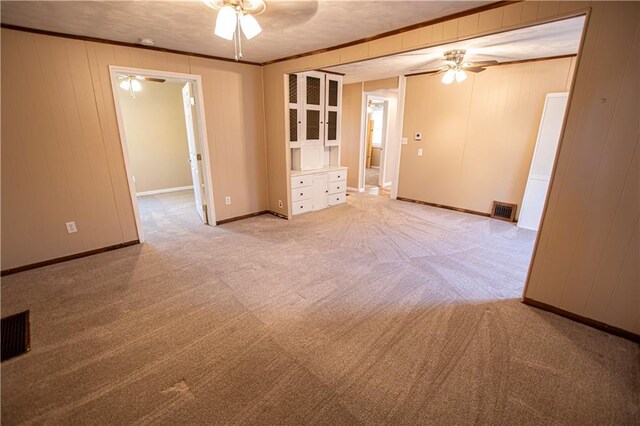 1340 S Osage St, Independence, MO 64055 - spare room featuring a ceiling fan, light carpet, ornamental molding, and baseboards