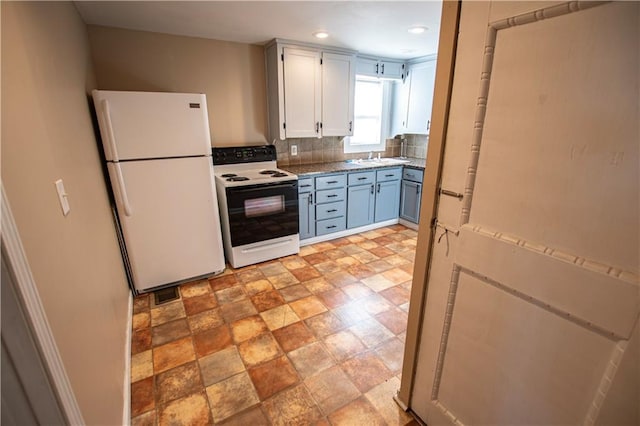 1340 S Osage St, Independence, MO 64055 - kitchen with freestanding refrigerator, electric range, backsplash, a sink, and light stone finish flooring