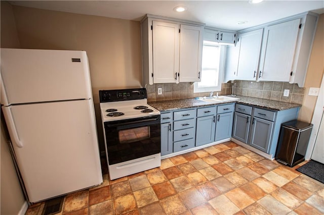 1340 S Osage St, Independence, MO 64055 - kitchen featuring electric stove, freestanding refrigerator, a sink, backsplash, and recessed lighting