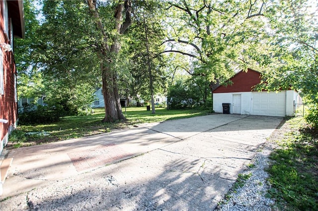 1340 S Osage St, Independence, MO 64055 - view of patio featuring an outdoor structure, a detached garage, and driveway