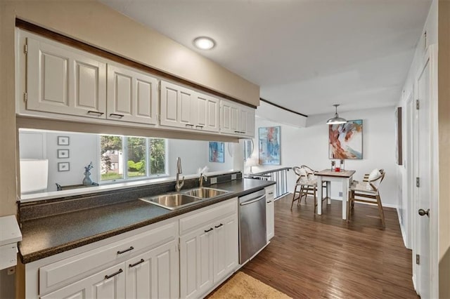 470 W 104th St Unit C, Kansas City, MO 64114 - kitchen with dishwasher, a sink, dark countertops, and dark wood-style flooring