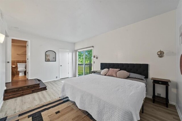 470 W 104th St Unit C, Kansas City, MO 64114 - bedroom featuring access to outside, wood finished floors, and ensuite bathroom