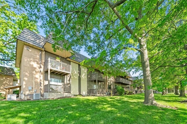 470 W 104th St Unit C, Kansas City, MO 64114 - back of house with a lawn, central AC, brick siding, and mansard roof