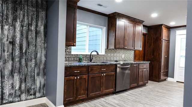 240 W 3rd Ave, Garnett, KS 66032 - kitchen with dishwasher, a sink, decorative backsplash, dark stone countertops, and baseboards