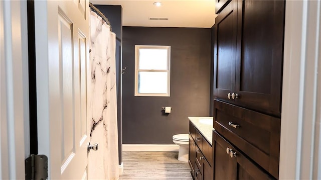 240 W 3rd Ave, Garnett, KS 66032 - bathroom with wood finished floors, baseboards, toilet, and vanity