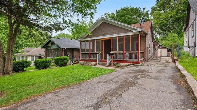 2512 Everett Ave, Kansas City, KS 66102 - view of front of house featuring driveway, a sunroom, a gate, and a detached garage