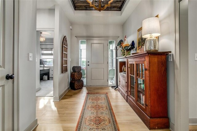 11809 E Ridgeview Ct, Peculiar, MO 64078 - entryway featuring light wood-style flooring, baseboards, a tray ceiling, and a chandelier