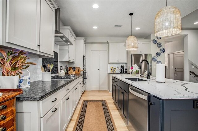 11809 E Ridgeview Ct, Peculiar, MO 64078 - kitchen featuring stainless steel appliances, a sink, light wood finished floors, wall chimney exhaust hood, and white cabinetry