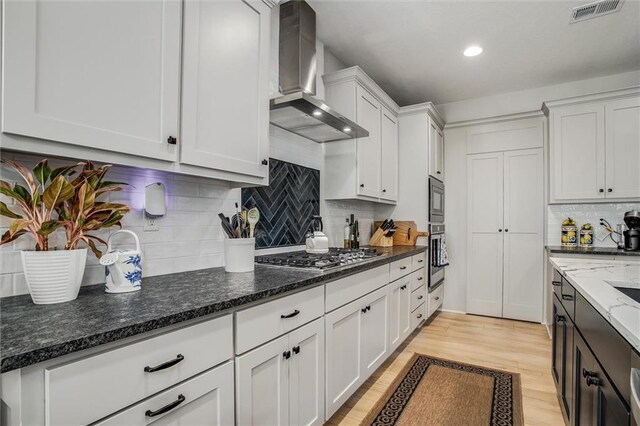 11809 E Ridgeview Ct, Peculiar, MO 64078 - kitchen featuring wall chimney range hood, stainless steel appliances, white cabinetry, light wood-style flooring, and recessed lighting