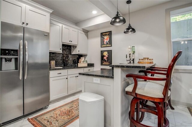 11809 E Ridgeview Ct, Peculiar, MO 64078 - kitchen with stainless steel fridge, light marble finish flooring, a sink, backsplash, and a kitchen bar