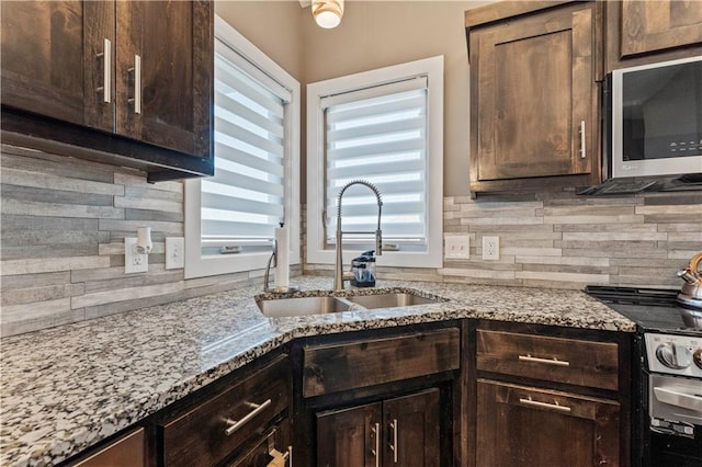 4108 NW 76th St, Kansas City, MO 64151 - kitchen with appliances with stainless steel finishes, a sink, backsplash, and dark brown cabinets
