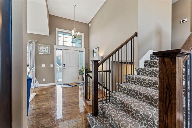 4108 NW 76th St, Kansas City, MO 64151 - foyer featuring high vaulted ceiling, stairs, baseboards, a chandelier, and wood finished floors