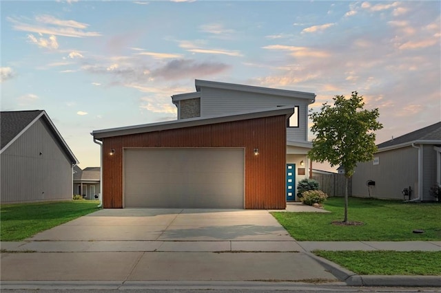 view of front of property with a lawn, concrete driveway, and an attached garage