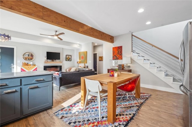 dining space with stairs, recessed lighting, ceiling fan, light wood-style floors, and beamed ceiling