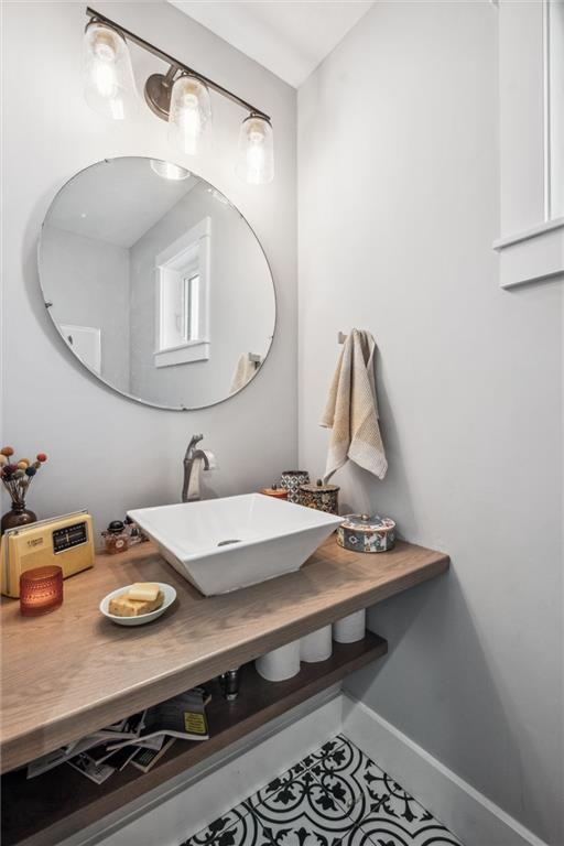bathroom with a sink, tile patterned flooring, and baseboards