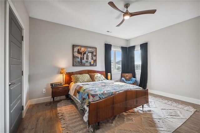 bedroom featuring baseboards, wood finished floors, and a ceiling fan