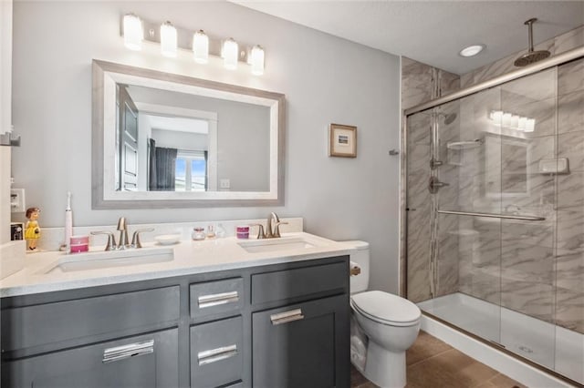 full bath with a shower stall, double vanity, toilet, tile patterned floors, and a textured ceiling