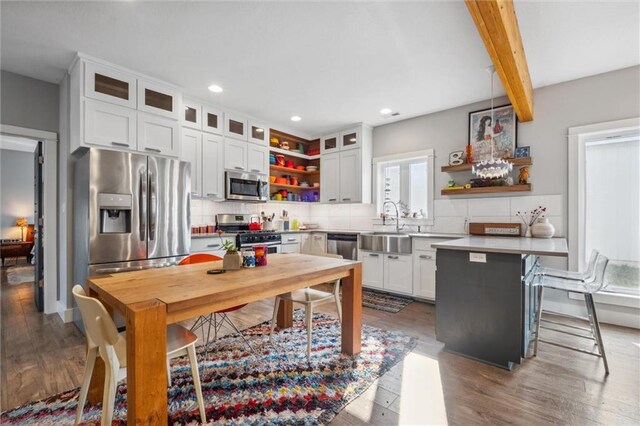 kitchen featuring appliances with stainless steel finishes, open shelves, backsplash, a peninsula, and recessed lighting