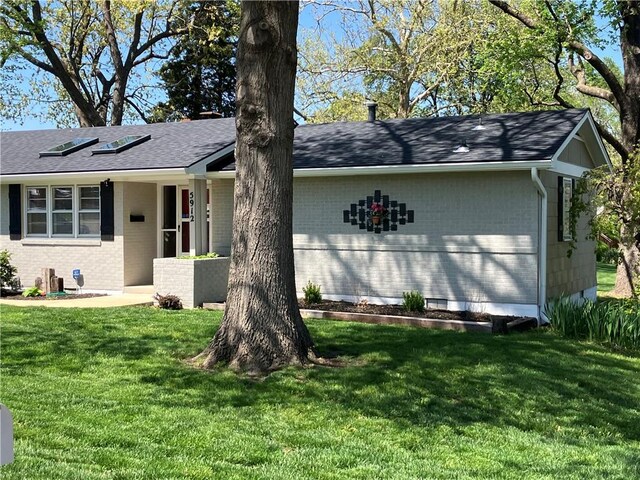 5912 Longview Rd, Kansas City, MO 64134 - view of front of home featuring brick siding, a front yard, and a shingled roof