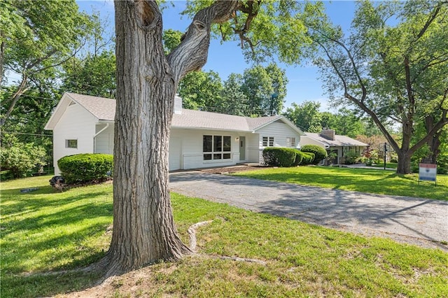 218 NW 43rd Ter, Kansas City, MO 64116 - ranch-style house with a chimney, driveway, and a front yard