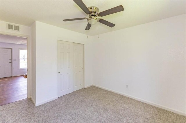 6021 E 151st Ter, Grandview, MO 64030 - unfurnished bedroom with carpet flooring, a closet, baseboards, and a ceiling fan